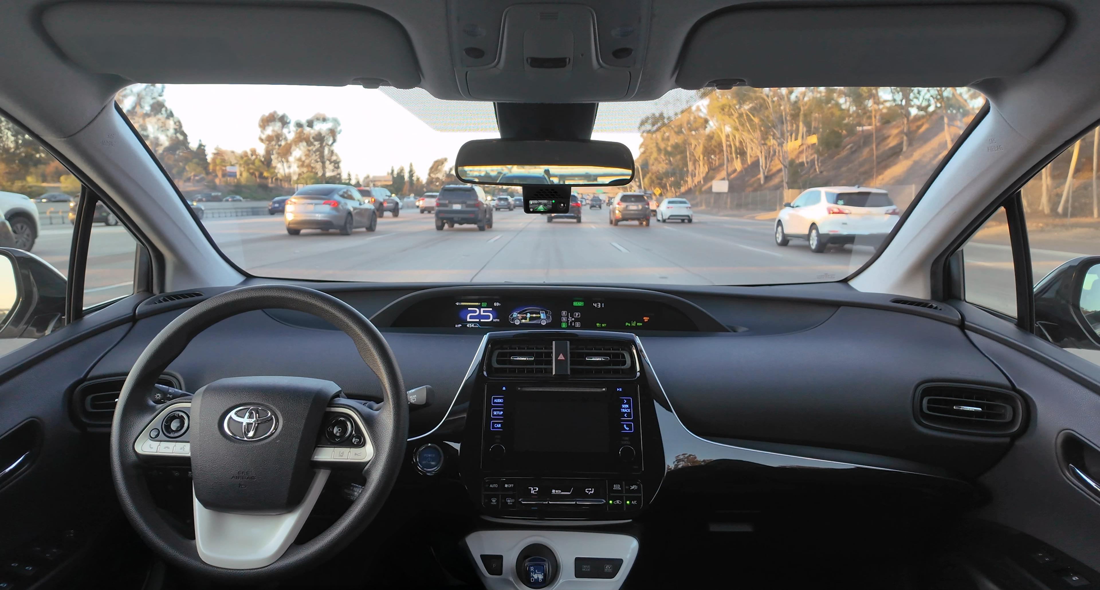 comma four mounted behind the rearview mirror in a car